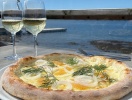 Här kan de lokala specialiteterna avnjutas med havsutsikt - som pizza med löjrom