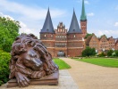 Foran Holstentor ligger to løver på vagt - den sovende og den vågne