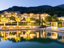 Hotellets indbydende poolområde med udsigt til sø og alpelandskab