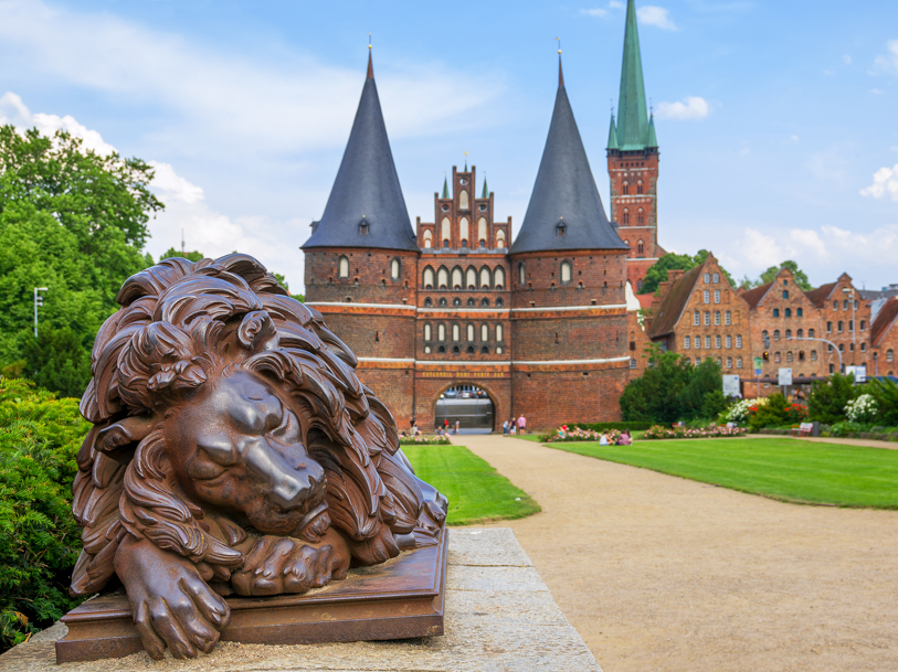 Foran Holstentor ligger to løver på vagt - den sovende og den vågne