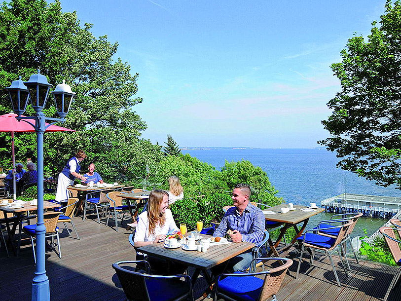 Ta en fika på ett av caféerna längs Kielfjorden och njut av utsikten över vattnet