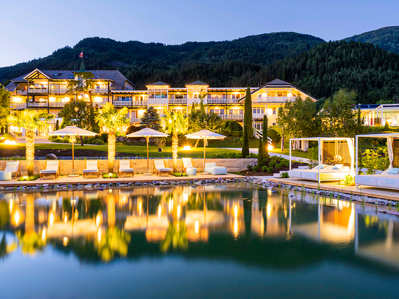 Hotellets indbydende poolområde med udsigt til sø og alpelandskab