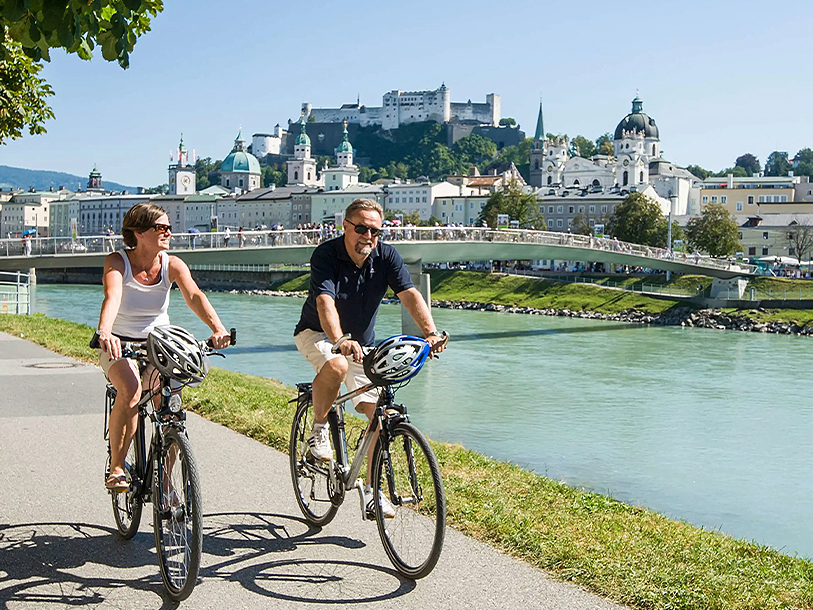 Njut av en cykeltur längs floden Salzach med utsikt över fästningskomplexet Hohensalzburg